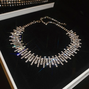 Close-up of sparkling diamond choker necklace with silver tassels in a gift box