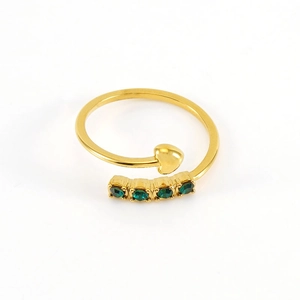 Minimalist gold bypass ring featuring a heart design and four inlaid green zircons