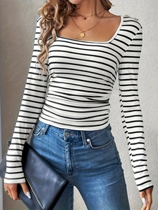 Maglia aderente a maniche lunghe a righe bianche e nere con jeans blu classici