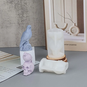 Macro detail of bird and skull silicone molds with purple wax casting on wood base