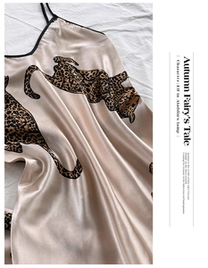 Detail view of champagne silk satin nightgown with leopard print on white bedsheets