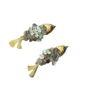 Fermaglio per capelli a forma di pesce dorato con scaglie di conchiglia e occhio blu su bianco