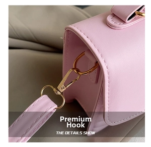 Detail of premium golden metal hook on pink leather crossbody bag with high texture