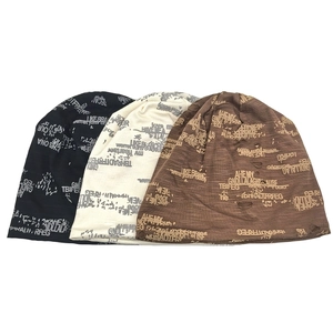 Distressed knit beanies with vintage letter patterns in black, cream, and brown