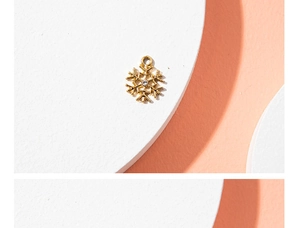 Golden snowflake charm with a sparkling crystal center shown on a clean white background