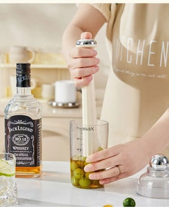 Close-up of professional plastic drink muddler crushing fresh grapes in a 500ml measuring cup