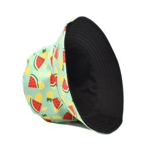 Détail d'un bob réversible avec imprimé pastèque et citron sur tissu vert clair