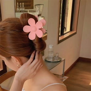 Pinza para el cabello con forma de flor rosa usada en un ambiente interior acogedor