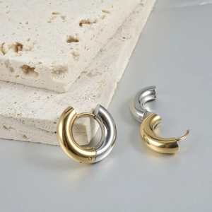 Minimalist two-tone chunky hoop earrings in gold and silver finish on stone display