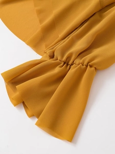 Detail of ginger yellow long sleeve top showing ruffle elastic cuffs and fabric texture