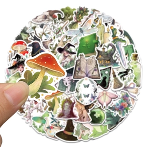 Close-up of a hand holding a red mushroom sticker from a forest witch sticker set