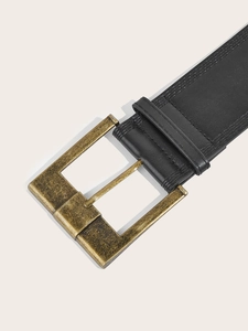Detail of vintage black leather wide belt with antique bronze metal buckle and stitching
