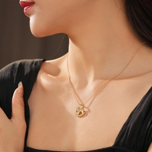 Gros plan d'un collier avec pendentif cheval doré minimaliste porté sur le cou