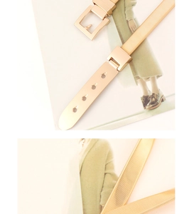 Detailed view of golden metal spring belt with square buckle and textured elastic band
