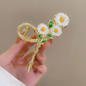 Golden alloy shark hair claw clip with white daisy floral design and enamel finish