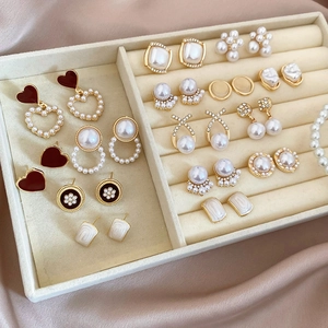 Detailed view of assorted geometric pearl earrings with gold plating and enamel finishes
