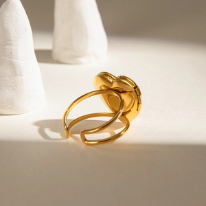 Detail of golden heart locket ring featuring a unique double-band open adjustable design