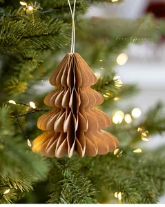 Close-up of honeycomb paper Christmas tree ornament hanging on a festive lighted tree