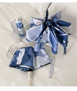 Detail of blue marble pattern folding umbrella with white handle and matching case