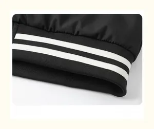 Close-up of black sport jacket hem with white double-stripe ribbed knit detail