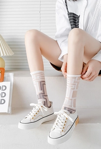 Detail showing white mesh mid-calf socks with purple geometric maze pattern and sneakers