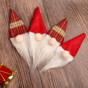 Set of 4 Christmas gnome plush ornaments with red and checkered hats on wooden background