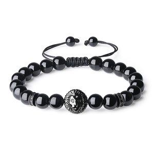 Detalle de pulsera de cuentas de ónice negro con cabeza de león y cordón trenzado ajustable