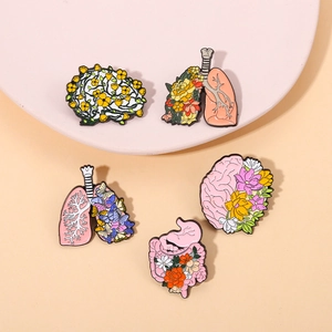 Detail showing five creative alloy enamel pins with floral organ designs on a pink tray