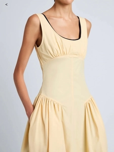 Détail de la robe sans manches jaune clair avec liseré noir et buste plissé vintage