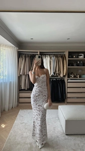 Détail du tissu en dentelle florale blanche et de la coupe ajustée de la robe longue
