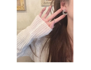 Close-up of elegant crescent leaf earrings with sparkling zircons worn by a model