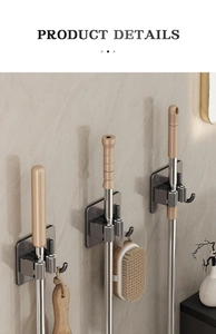 Détail du support de balai mural gris fusil avec crochets sur mur en marbre