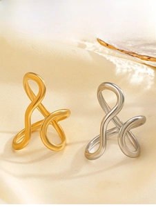 Detail of interlocking gold and silver rings on cream silk fabric with soft lighting