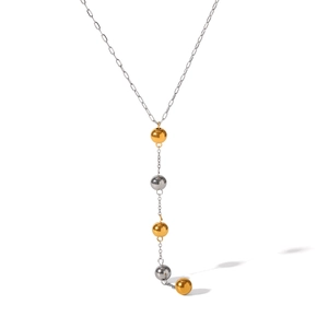 Detail of two-tone Y-shaped necklace with gold and silver beads on a polished metal chain