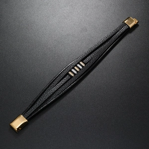 Detail of multi-layer black leather bracelet with gold-silver diamond accents and magnetic clasp