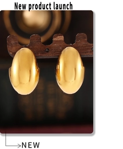 Macro shot of polished gold oval hoop earrings on a dark wooden display stand