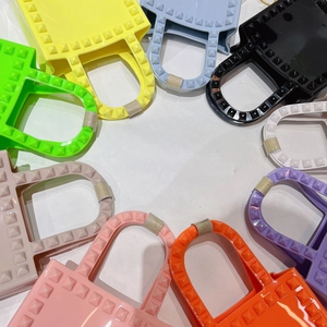 Top view of colorful mini PVC jelly bags with rivet textures in a circular arrangement