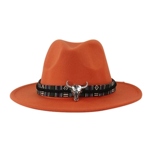 Dettaglio di cappello in feltro arancione con fascia etnica e teschio di toro argento