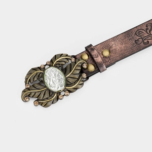 Detail of vintage leather belt with bronze leaf buckle and large green crystal gemstone