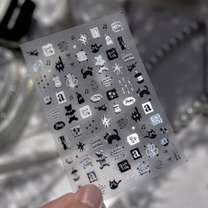 Macro shot of 3D embossed nail stickers featuring metal stars and black cat motifs