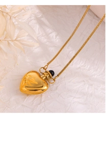 Macro detail of vintage 18K gold heart locket pendant with floral engraving on snake chain