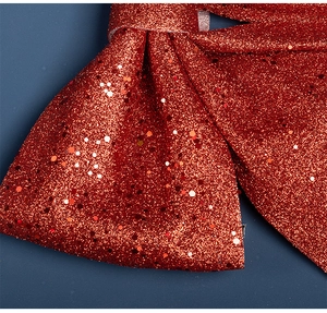 Vue macro de paillettes rouges et texture scintillante sur le grand nœud de Noël