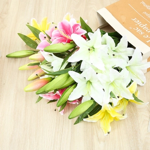 Artificial lily bouquet in white pink and yellow colors displayed in a brown paper bag
