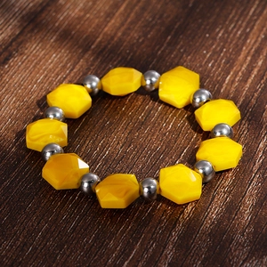 Detail of yellow hexagonal beads and silver metal spheres on a bohemian beaded bracelet
