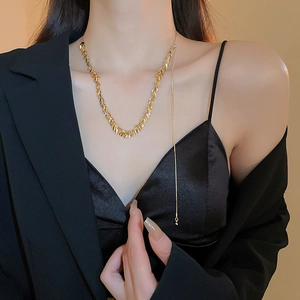 Primo piano dell'elegante girocollo a forma di foglia d'oro e collana su un modello