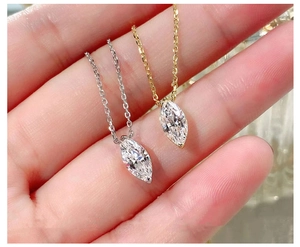 Detail of S925 silver gold necklaces featuring marquise-cut zircon pendants held in hand