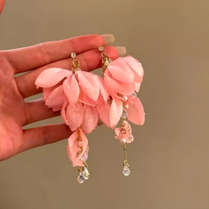 Close-up of pink fabric petal earrings with pearls and gold-tone dangles