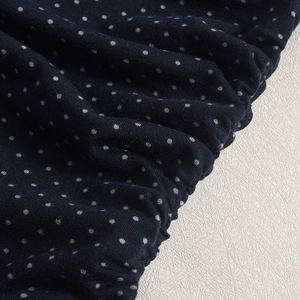 Macro du tissu en maille bleu marine à pois blancs avec détails élastiques froncés