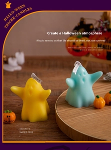 Detail of cute ghost scented candles in yellow and light blue with a small pumpkin ornament