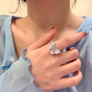 Sparkling silver butterfly ring with blue crystals on finger, elegant vacation style